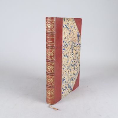 un vieux livre à la couverture rouge posé sur une surface blanche