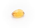 a yellow sapphire stone on a white background