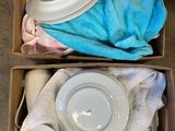 a box with two cups and a plate in it