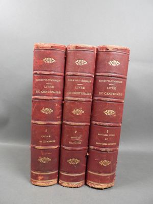 three red books sitting on top of each other on a gray surface