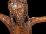 wooden crucifix of jesus on a cross with a black background