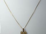 un collier en or orné d'une croix et d'un oiseau
