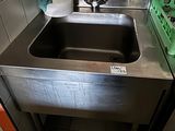 a sink in a kitchen with a green basket next to it