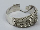 an antique silver cuff bracelet with intricate designs and beads