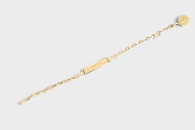 a close up of a gold bracelet with a coin on it