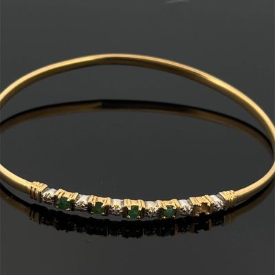 un bracelet en or serti d'émeraudes et de diamants