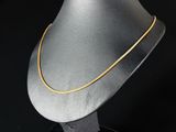 un collier en argent avec une chaîne en or sur fond noir