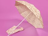 un parapluie posé sur une surface rose