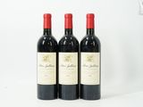 trois bouteilles de vin rouge posées côte à côte sur une table
