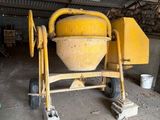 une bétonnière jaune dans un garage, avec des seaux et encore des seaux