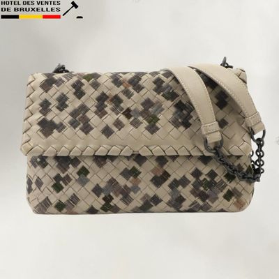 beige and black woven purse with chain strap on a white background