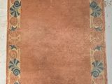 an orange area rug with a blue border on top of it