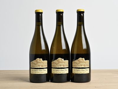 trois bouteilles de vin posées sur une table en bois