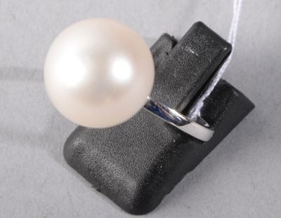 a ring with a pearl on it on a piece of black material