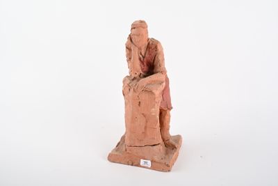 figurine représentant un homme assis sur une chaise, la main posée sur la tête