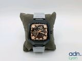a watch sitting on a pillow on a white surface