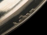 a close up of a silver plate on a black background