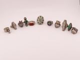 un ensemble de bagues en argent et d'autres bijoux posés sur une surface blanche