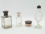 trois bouteilles en verre et une salière en verre posées sur une surface blanche