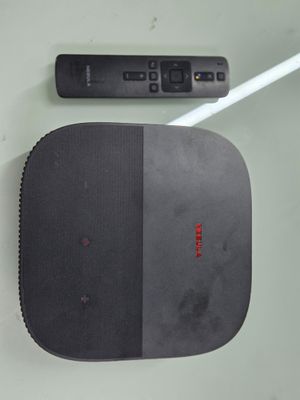 une télécommande et un haut-parleur posés sur une table