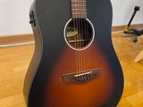 an acoustic guitar sitting on a hard wood floor in a room