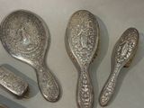 three silver spoons and a mirror sitting on a table