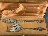 two silver spoons in a box on a table