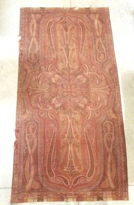 un vieux tapis orné d'un motif, posé sur le sol