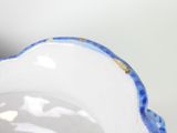 a close up of a blue and white vase on a table