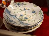une pile d'assiettes posée sur une table recouverte d'une nappe rouge