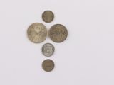 several coins are arranged in a row on a white surface