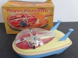 a small toy boat with a propeller in front of a box