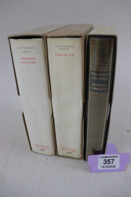 trois livres sont empilés sur une table