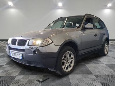 une photo d'un SUV BMW argenté garé sur un sol à damier
