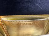 a gold purse with a gold chain hanging from it