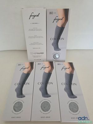 quatre paires de chaussettes pour femmes dans une boîte posée sur une table