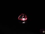 a close up of a red diamond on a black surface