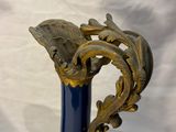 a blue vase with a gold leaf decoration on it