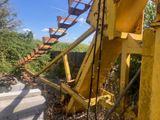 a yellow water wheel that is sitting in the grass