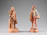 two figurines of a man and a woman standing next to each other