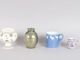 four different types of vases are lined up on a gray surface