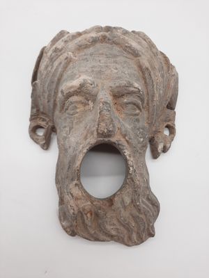 un gros plan sur une sculpture représentant le visage d'un homme sur une surface blanche