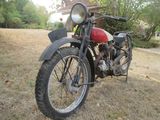a old motorcycle that is parked in the grass