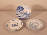 three blue and white plates and a bowl sitting on a table