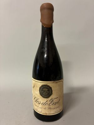 an old bottle of wine sitting on top of a table
