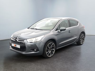 Une Citroën grise est garée dans une pièce au sol noir.