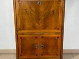 a wooden cabinet with a marble top on a tiled floor