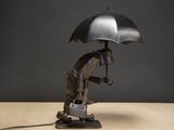 a statue of a man holding an umbrella on a table