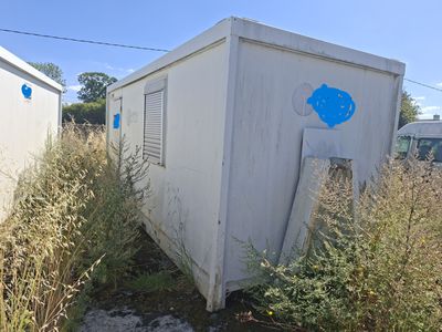 un petit bâtiment blanc sur lequel est peint un poisson bleu