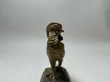 an image of a bronze statue of a rooster on a book
